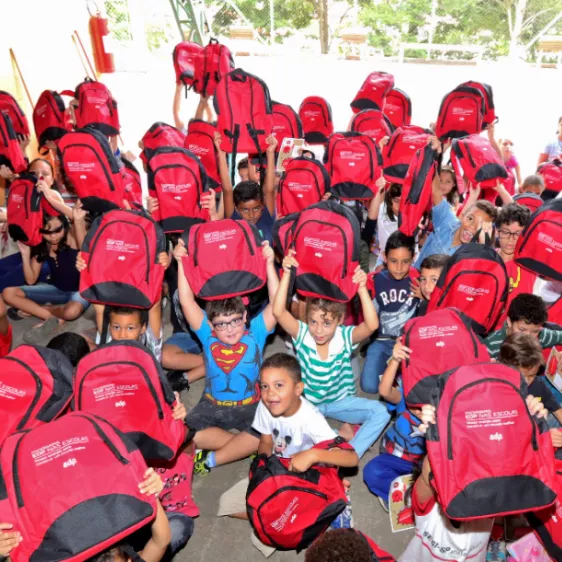 crianças felizes com mochila vermelha