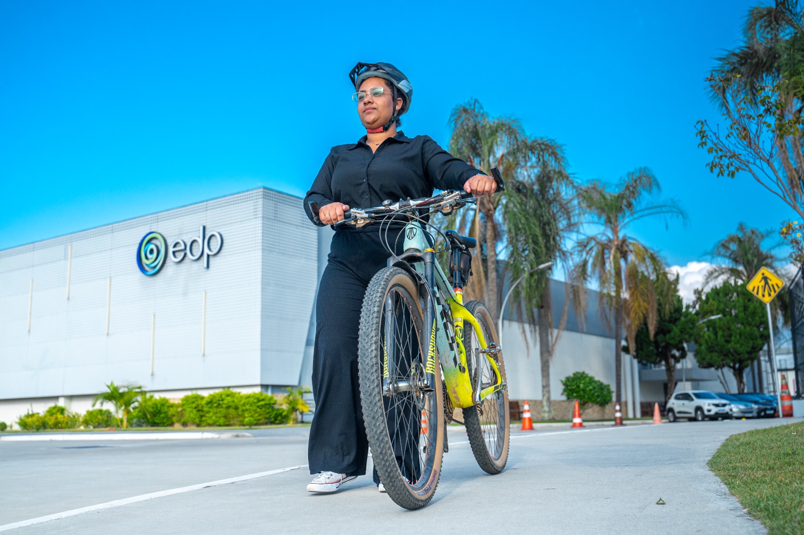 Colaboradora da EDP andando com bicicleta no estacionamento