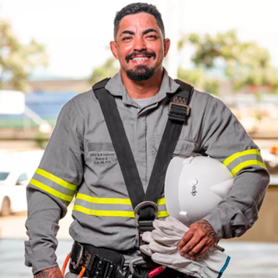 Colaborador eletricista da EDP uniformizado e com capacete sorrindo