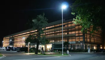 Prédio corporativo do E-Business Park à noite, com iluminação interna e externa acesa